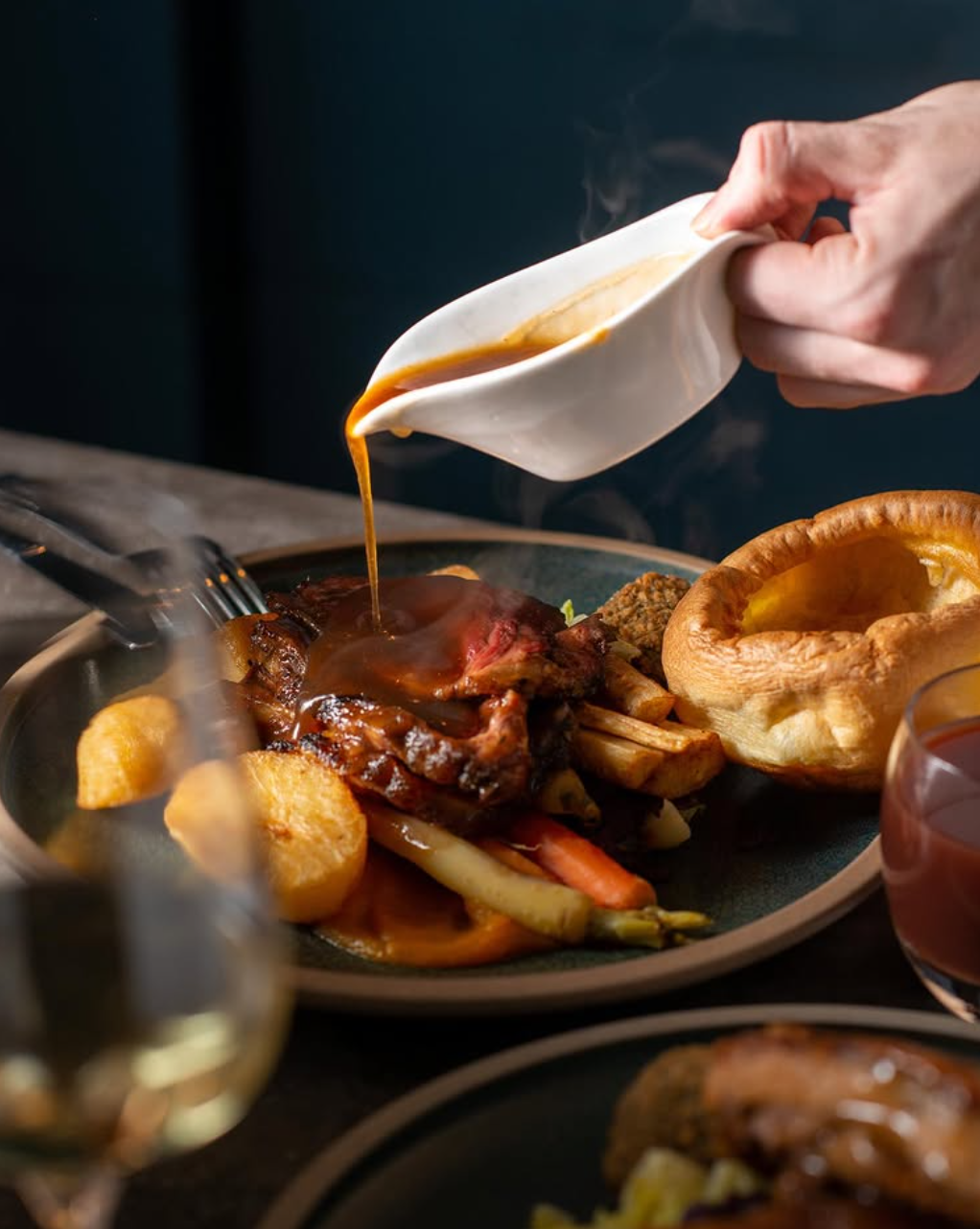 Gravy being poured over a festive roast at SIX