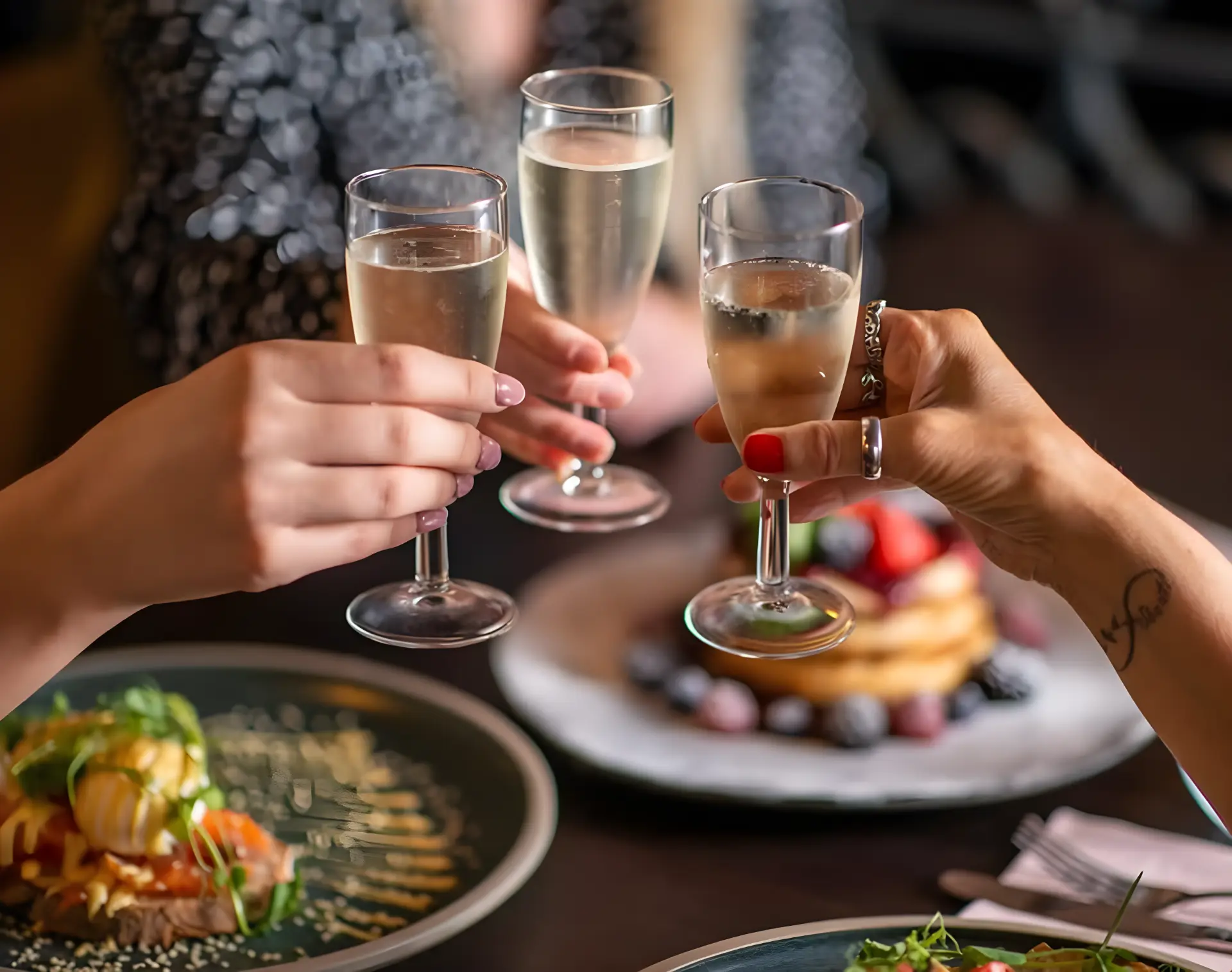 Friends raising glasses of fizz over brunch