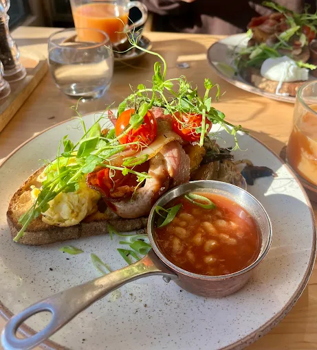 A generous breakfast with eggs, bacon, tomatoes and beans