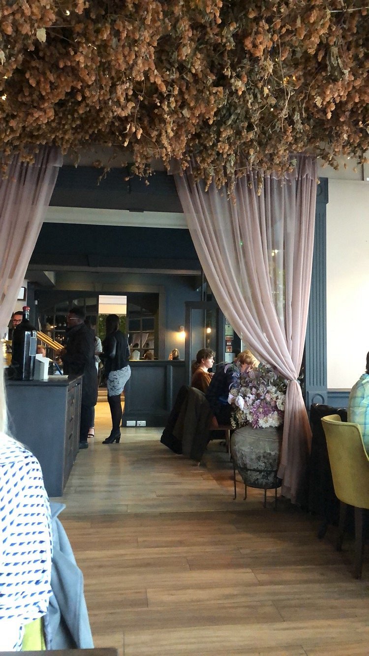 A view through the curtains into a lively dining room at SIX
